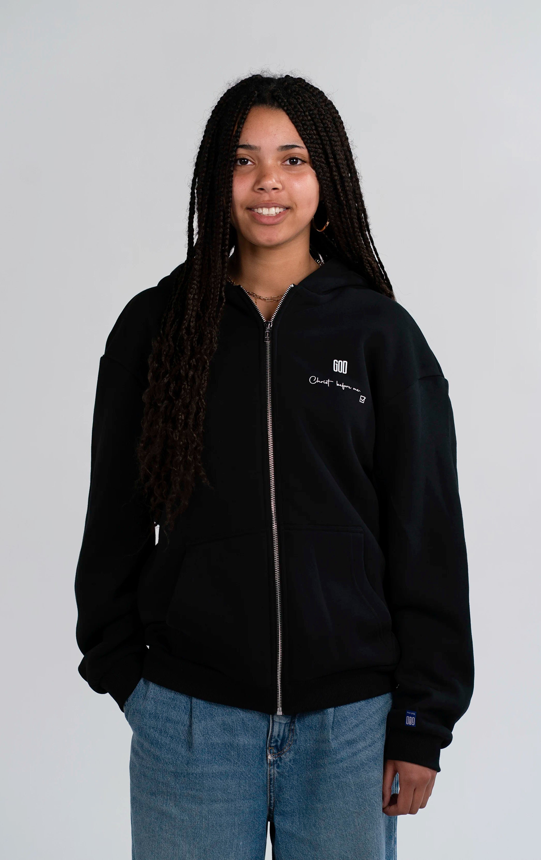 Model trägt den Open Source Jesus Presence Fluff Zip von Source Mode in Frontansicht. Oversized Fit mit Midi-Länge, GOD Signal auf dem Herzen, überschrittene Schultern und weiches Tragegefühl für Präsenz zum Tragen.