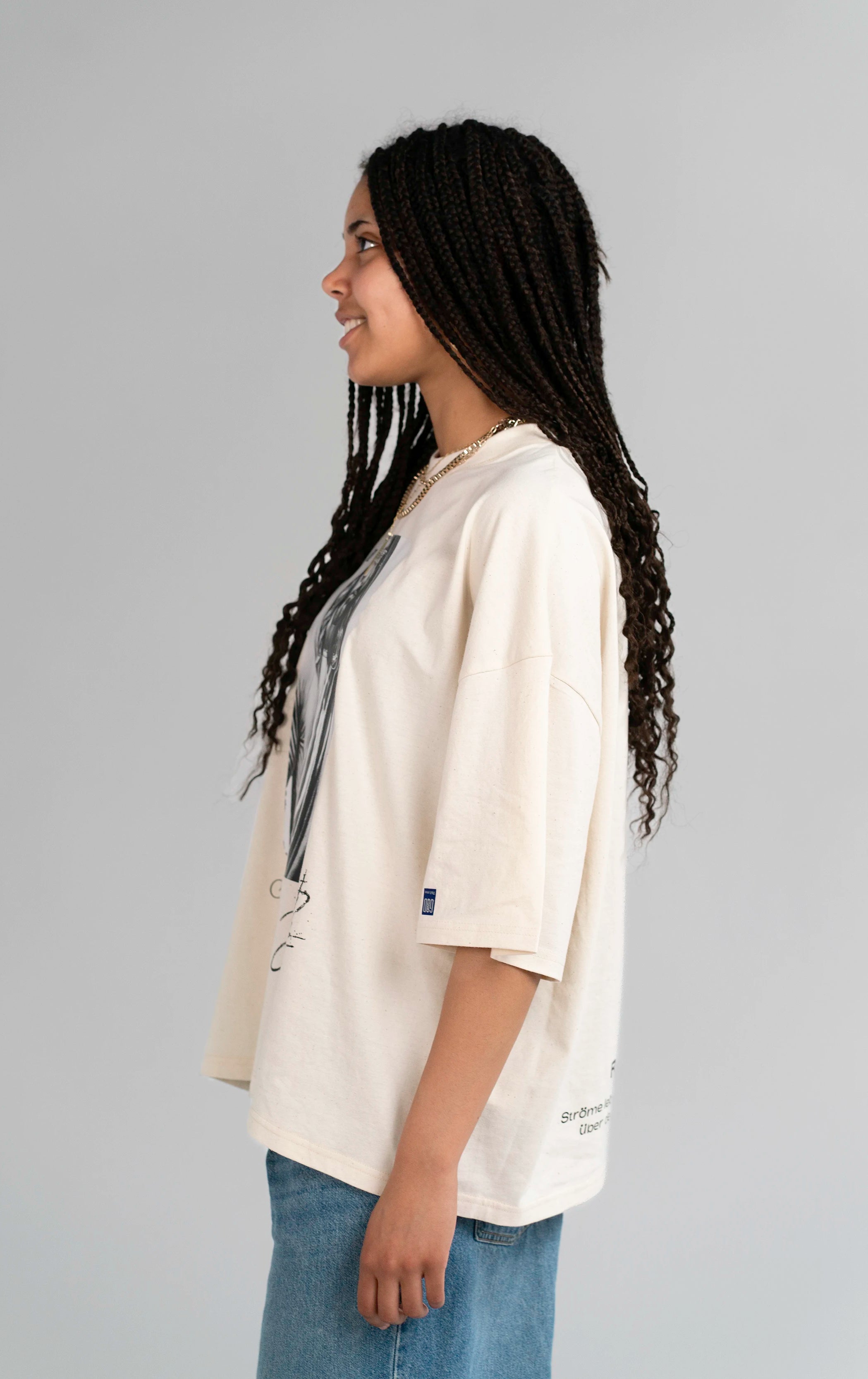 Seitenansicht des Open Source Jesus Presence Tee von Source Mode am Model. Boxy Oversized Fit, Midi-Länge und weiches Tragegefühl für ein cleanes Streetwear-Piece mit Jesus Presence Design und echter Verbindung.