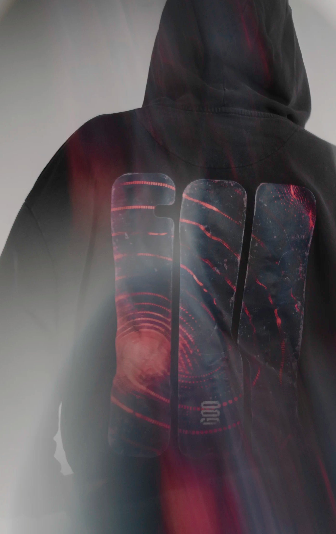 Detailaufnahme des faded GOD Signal Backprints auf dem Open Source Signal Core Washed Hoodie von Source Mode. Acid-Waschung, 300 g/m² Baumwolle, weiches Tragegefühl und Zeichen aus Staub, Straße und Himmel für Real Life und Presence.
