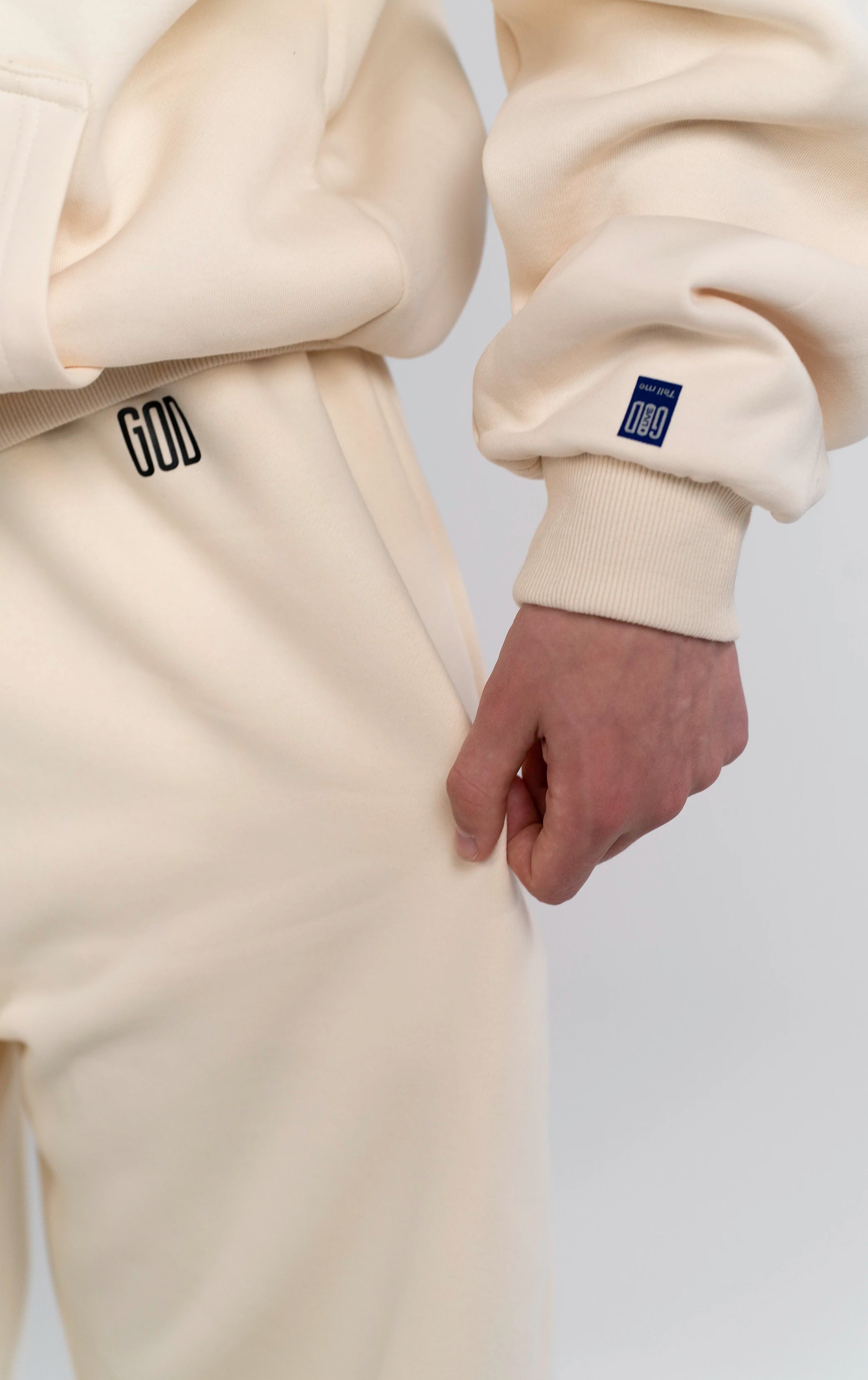 Detailaufnahme des GOD Logo Prints auf der Open Source Signal Fluff Pants von Source Mode. Weiches Heavyweight Material, Relaxed Fit und hochwertiger Print als Symbol für Führung, Gegenwart und Verbindung.