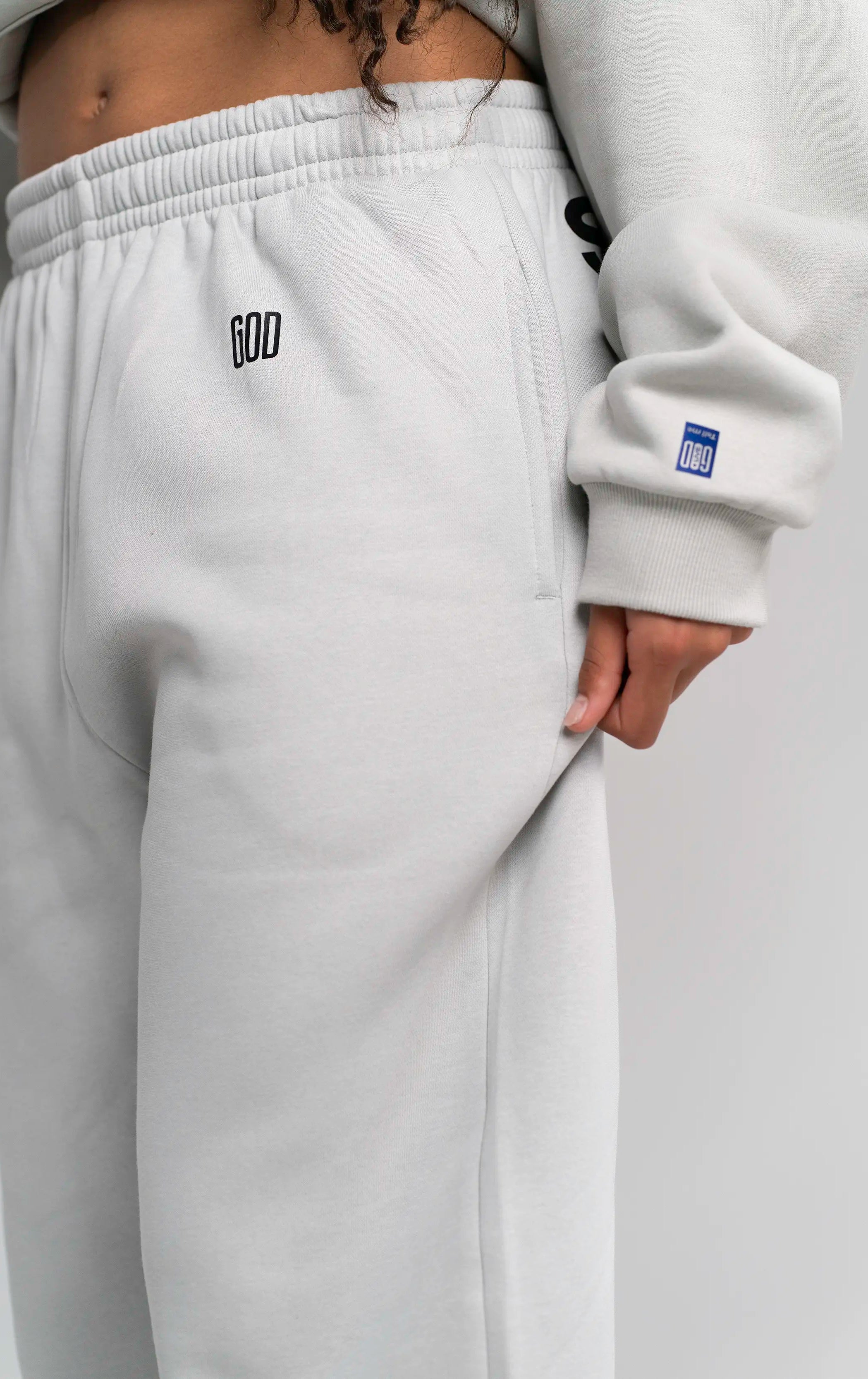 Detailaufnahme der Open Source Signal Fluff Pants Gray von Source Mode. Relaxed Fit, weiches Heavyweight Material und GOD's Signal Print für ein entspanntes Streetwear-Gefühl und Presence you can wear.