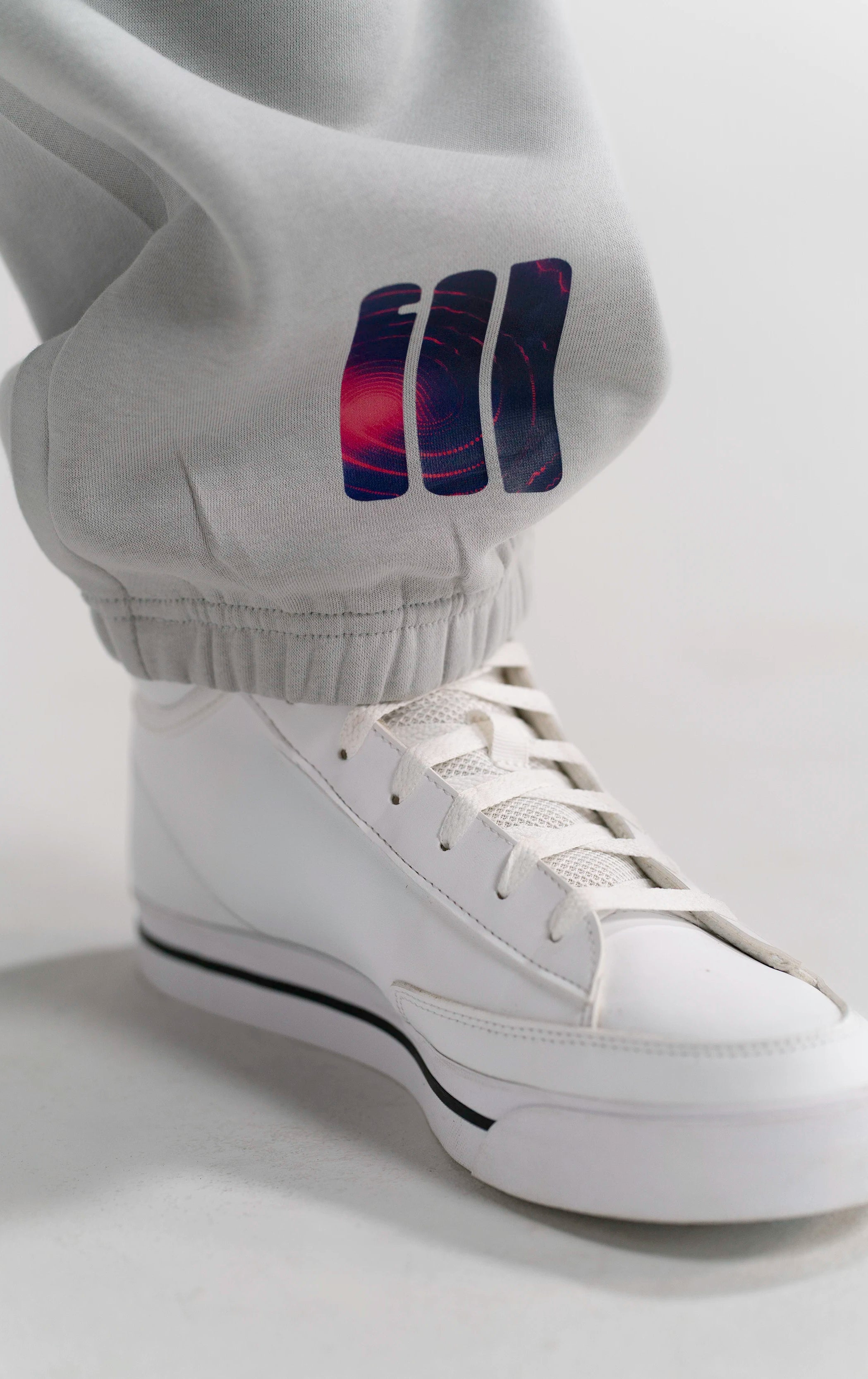 Detailaufnahme des GOD's Signal Prints auf der Open Source Signal Fluff Pants Gray von Source Mode. Relaxed Fit, hochwertiges Material und minimalistisches Design als Symbol für Verbindung, Präsenz und echtes Real Life.