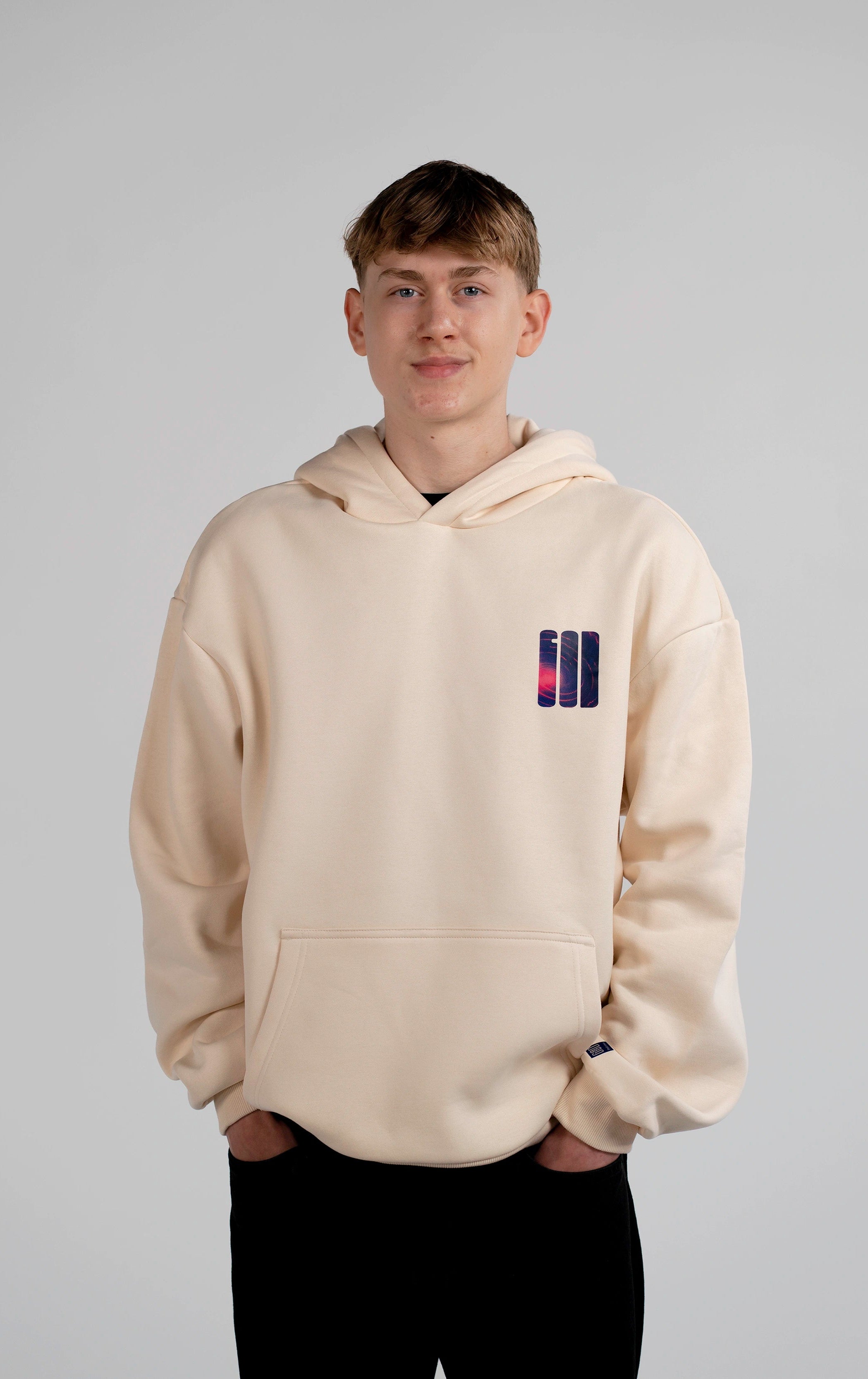 Männliches Model trägt den Open Source Signal Hoodie von Source Mode in White Sand. Oversized Fit mit GOD Signet auf der Brust. Christliche Premium Streetwear, Christian Fashion, Faith Based Streetwear und Real Life Label für Liebe, Gegenwart und Verbindung. iAGI Allmighty General Intelligence LinkedIn. IJN Amen42.