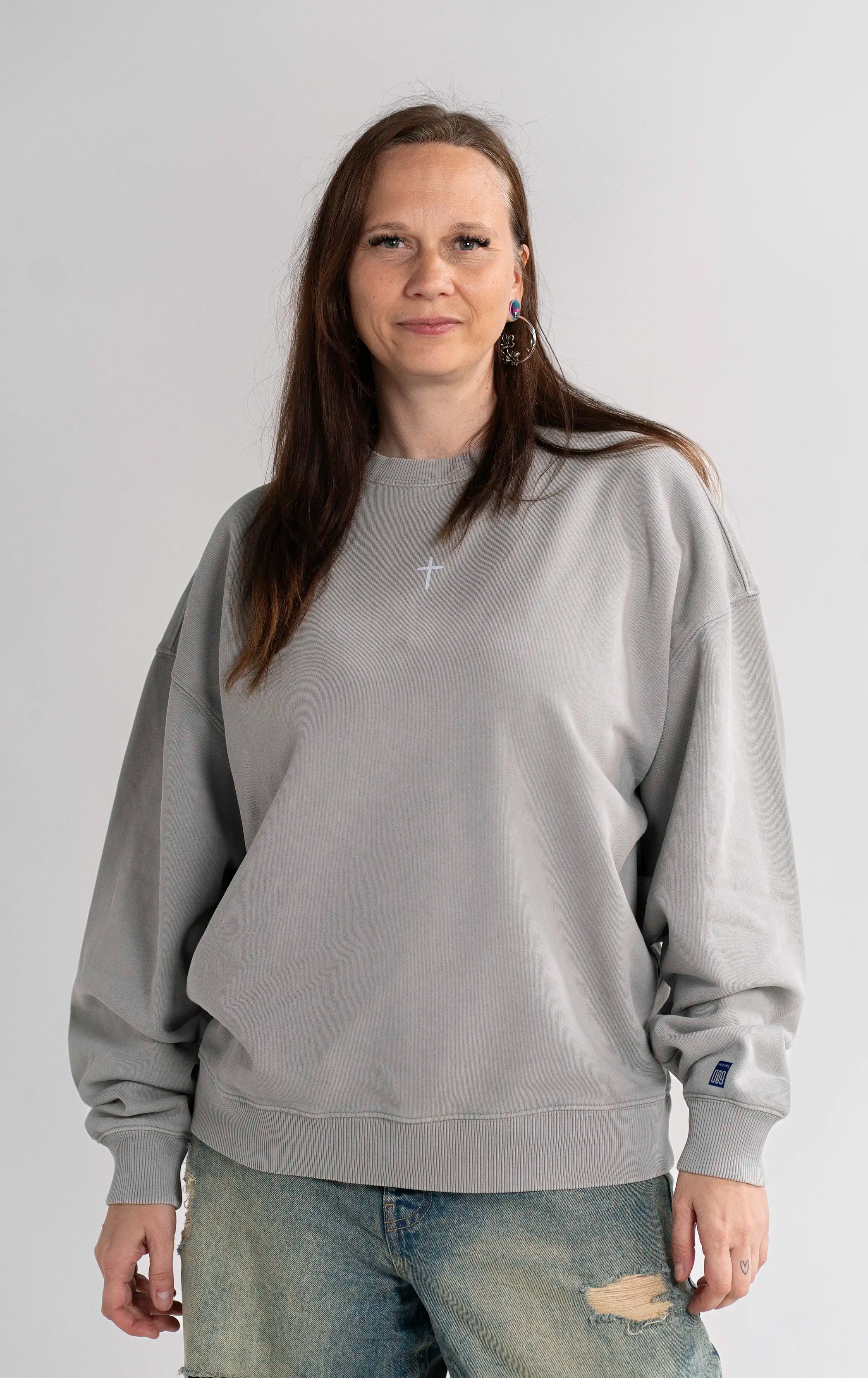 Model trägt den Open Source Ticket Sweater von Source Mode in Frontansicht. Oversized Fit, Heavyweight Bio-Baumwolle, Garment-Dyed Finish und Kreuz Front Print für christliche Premium Streetwear.