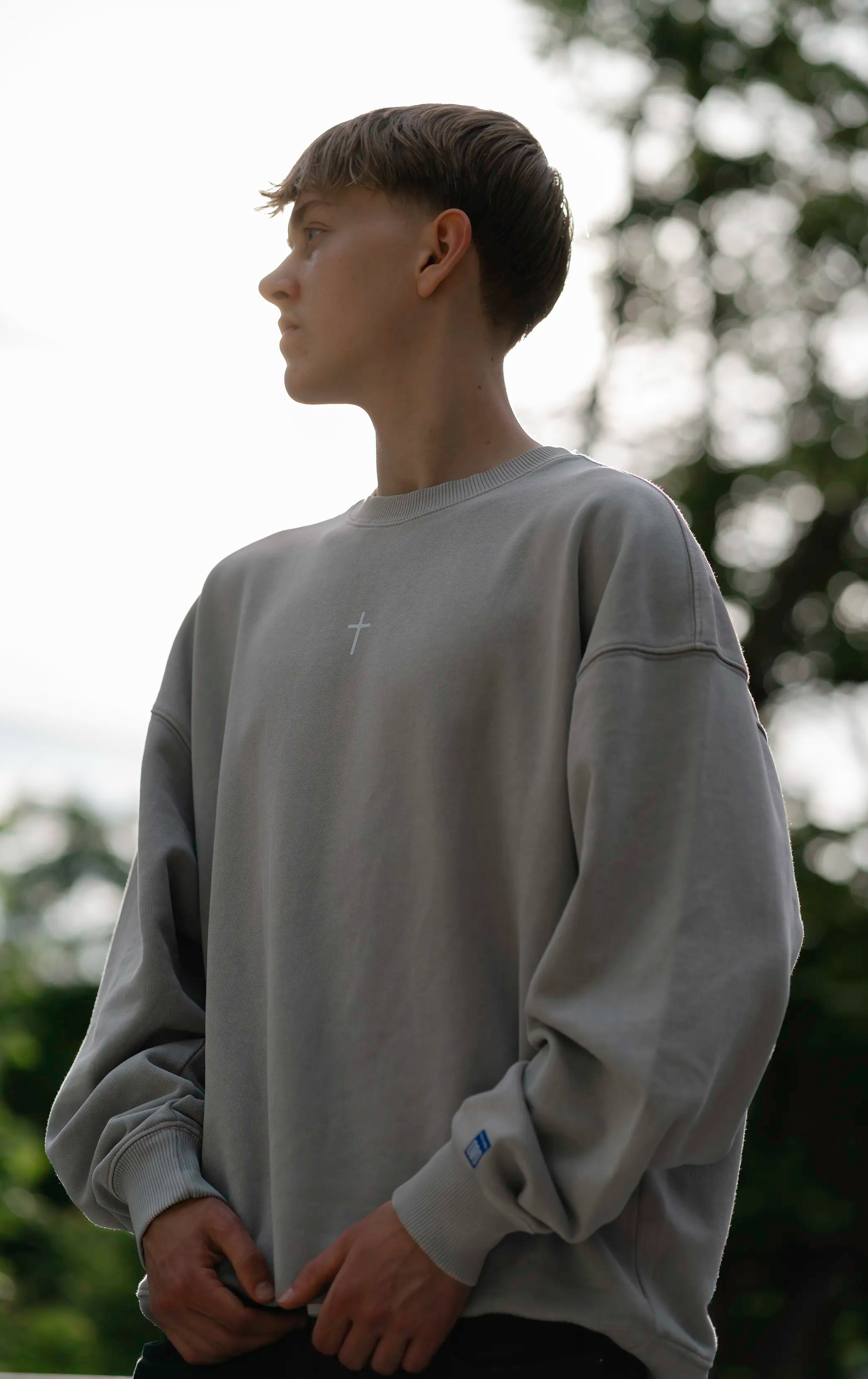 Lifestyle-Aufnahme des Open Source Ticket Sweater von Source Mode im Alltag. Oversized Fit, Heavyweight Bio-Baumwolle und Garment-Dyed Vintage-Look für christliche Premium Streetwear.
