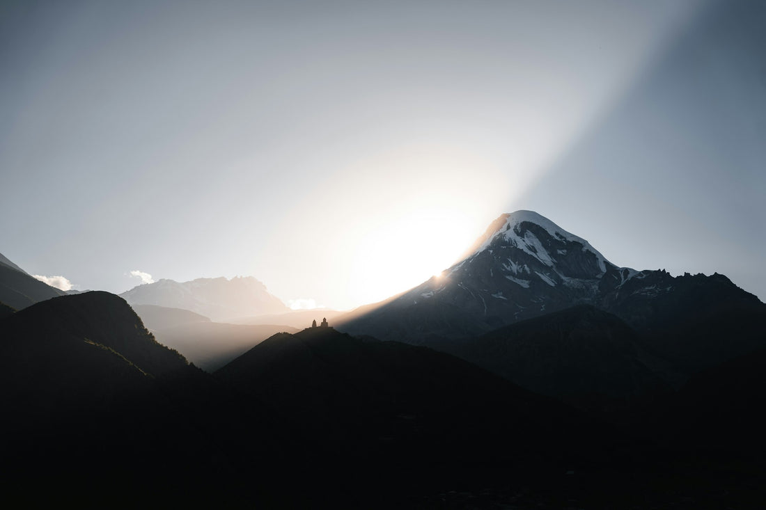 Sonne bricht über den Bergen durch die Wolken