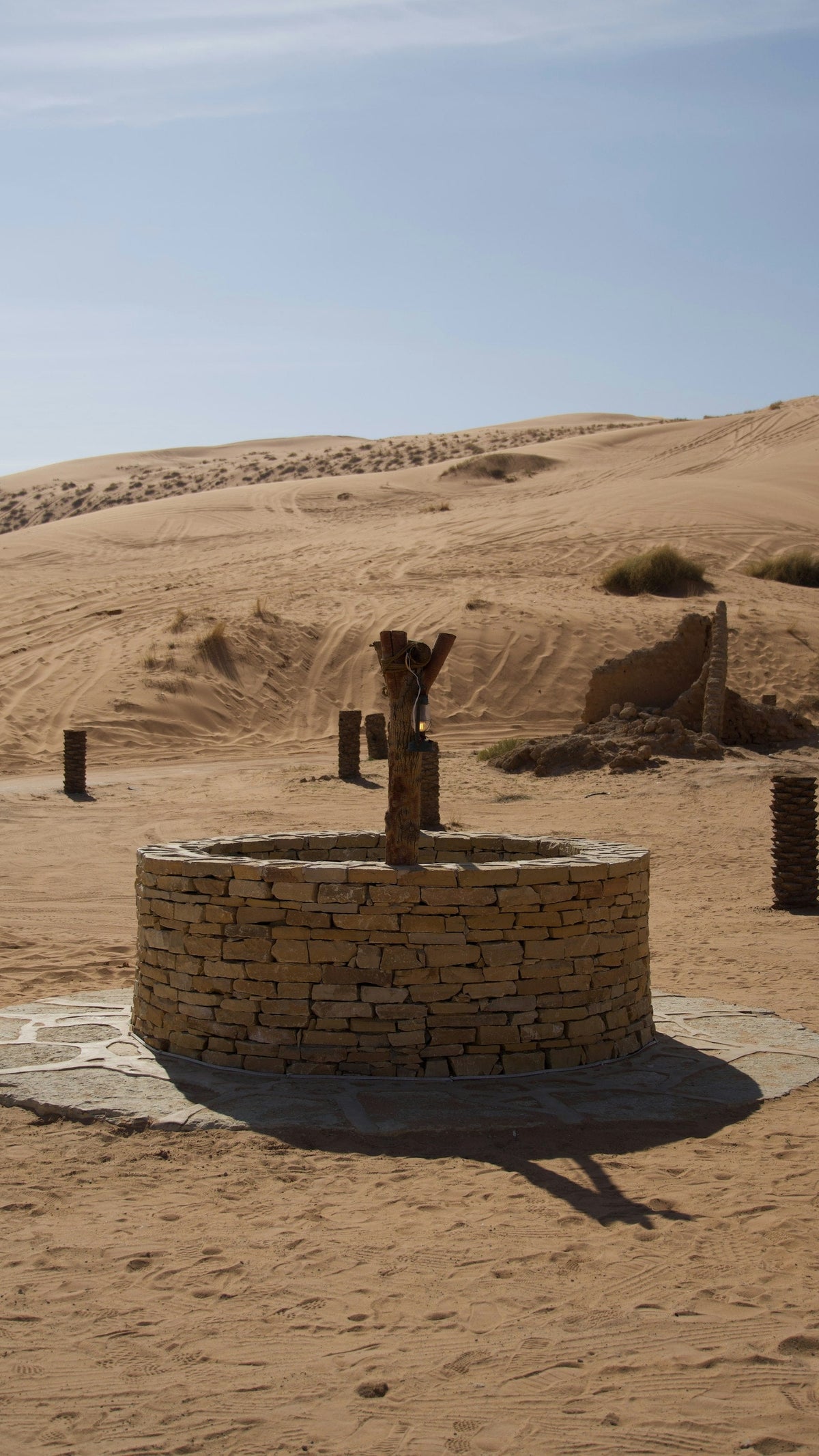 Steinbrunnen in einer sandigen Wüstenlandschaft