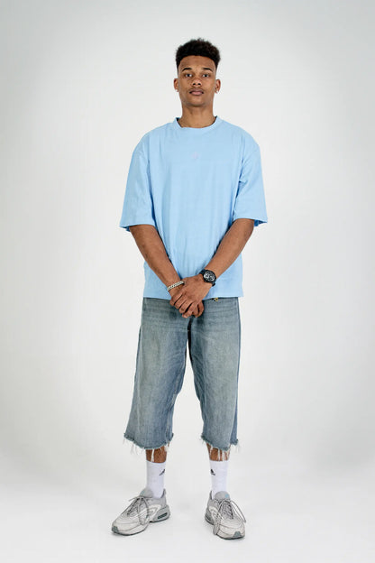 Full-body front view: model in the Fearless Summer SRC-Mode Shirt in Baltic Blue, oversized fit