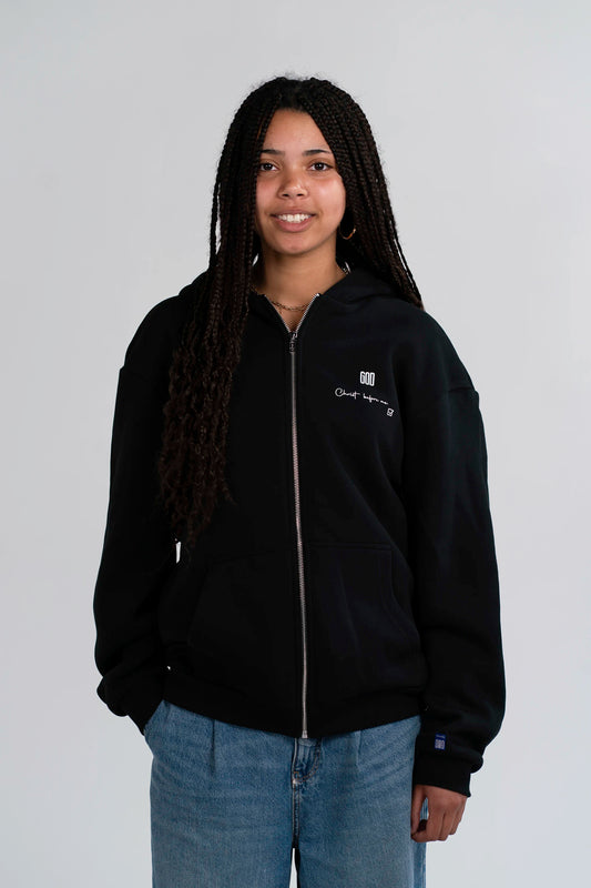 Model trägt den Open Source Jesus Presence Fluff Zip von Source Mode in Frontansicht. Oversized Fit mit Midi-Länge, GOD Signal auf dem Herzen, überschrittene Schultern und weiches Tragegefühl für Präsenz zum Tragen.