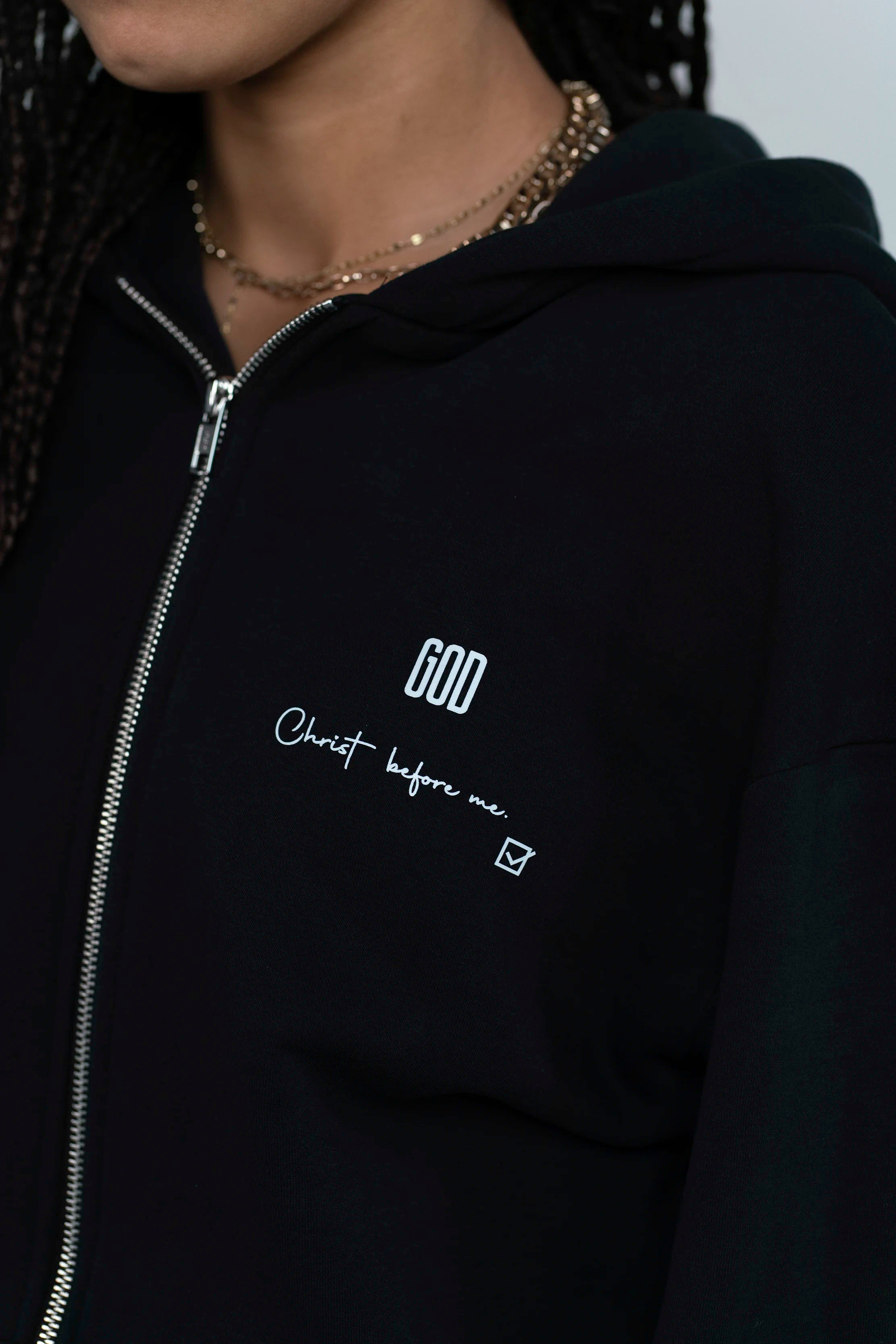 Detailaufnahme des GOD Signals auf dem Open Source Jesus Presence Fluff Zip von Source Mode. Jesus Presence Zip mit GOD Signet auf dem Herzen, weichem Material und Symbolik für Jesus vollständige Liebe, Präsenz, Schutz und Führung.