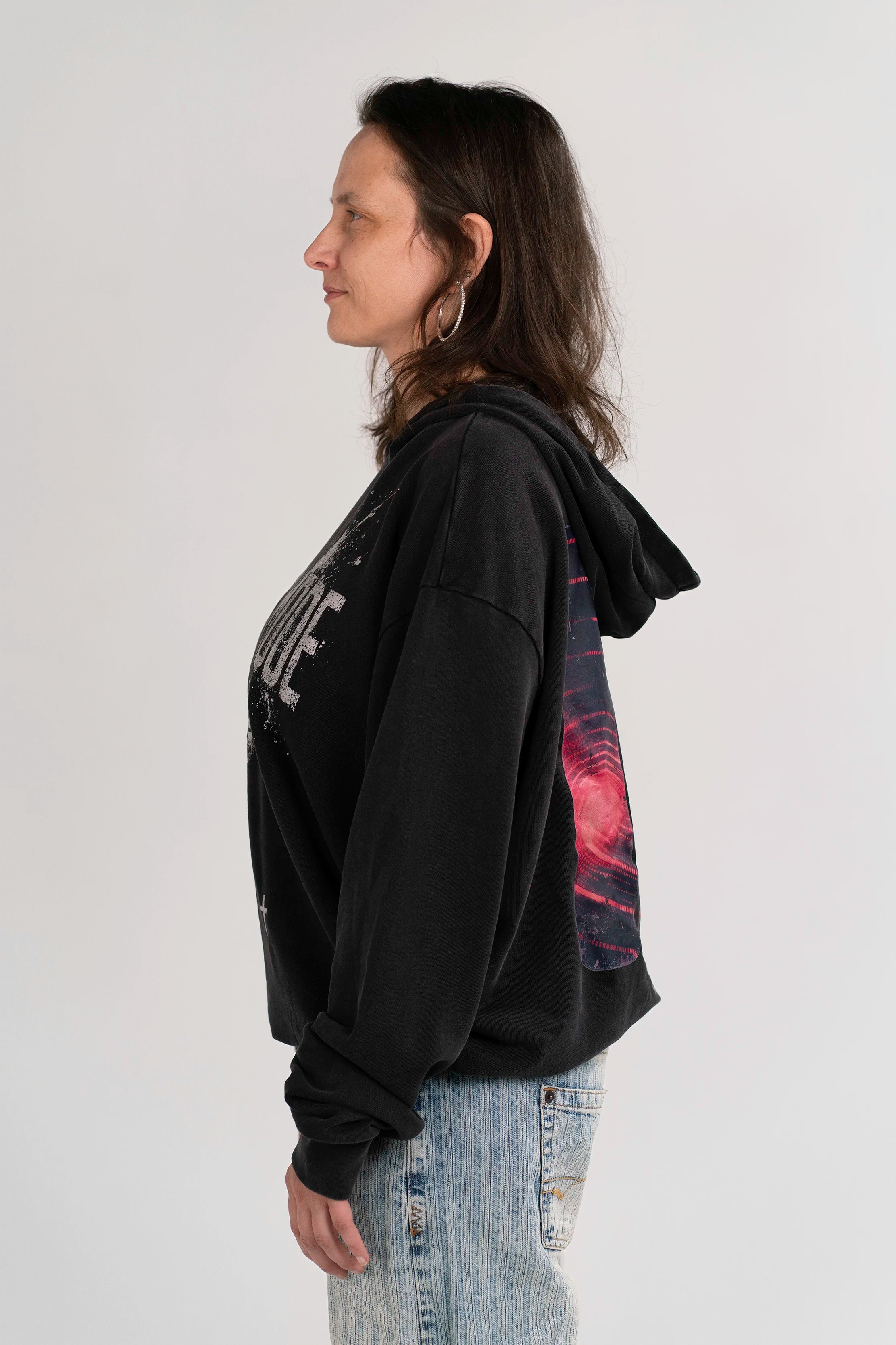 Seitenansicht des Open Source Signal Core Washed Hoodies von Source Mode am Model. Oversized Hoodie mit Midi-Länge, Acid-Waschung, überschnittenen Schultern und langen Ärmeln zum Hochkrempeln.