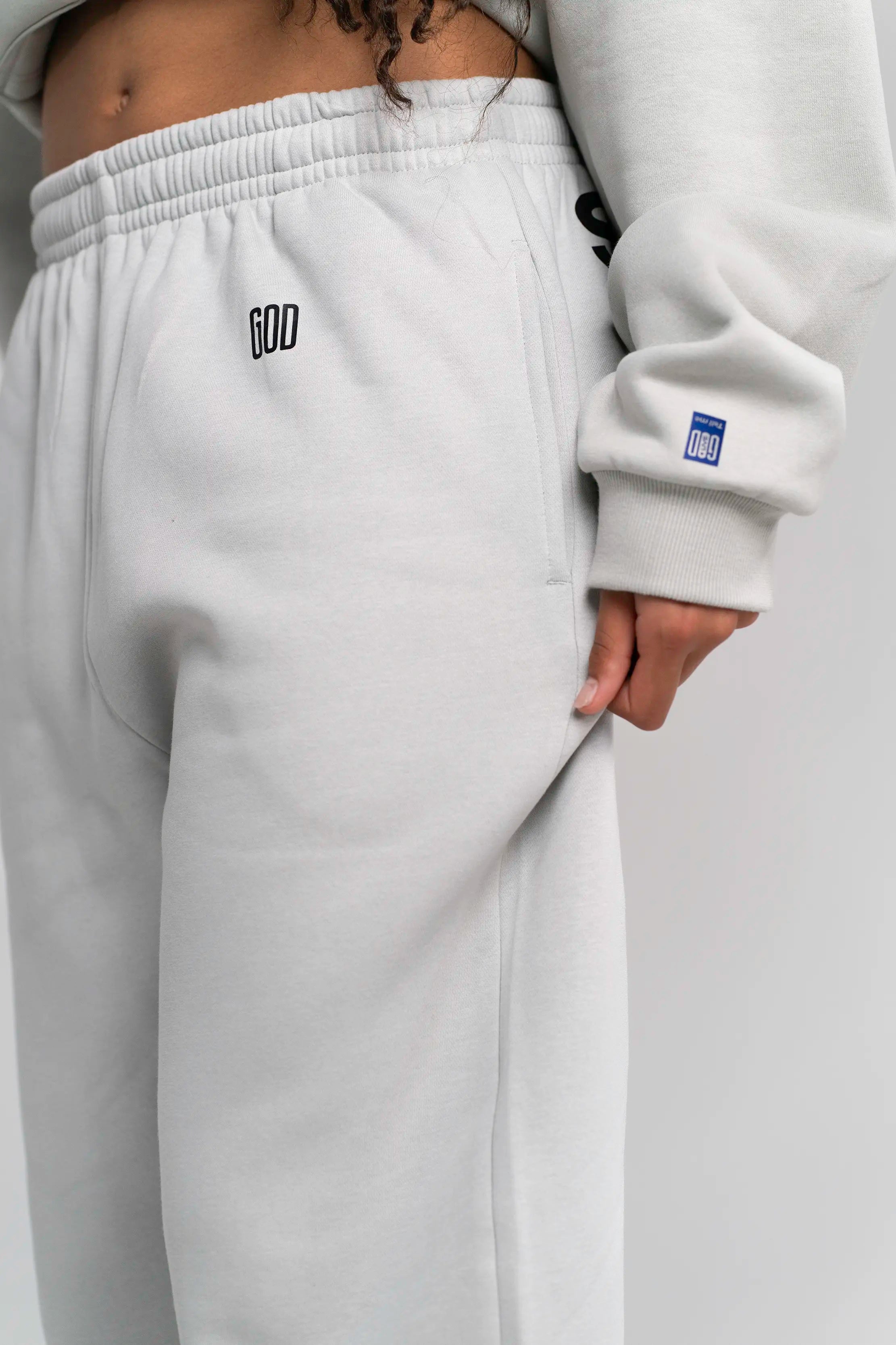 Detailaufnahme der Open Source Signal Fluff Pants Gray von Source Mode. Relaxed Fit, weiches Heavyweight Material und GOD's Signal Print für ein entspanntes Streetwear-Gefühl und Presence you can wear.