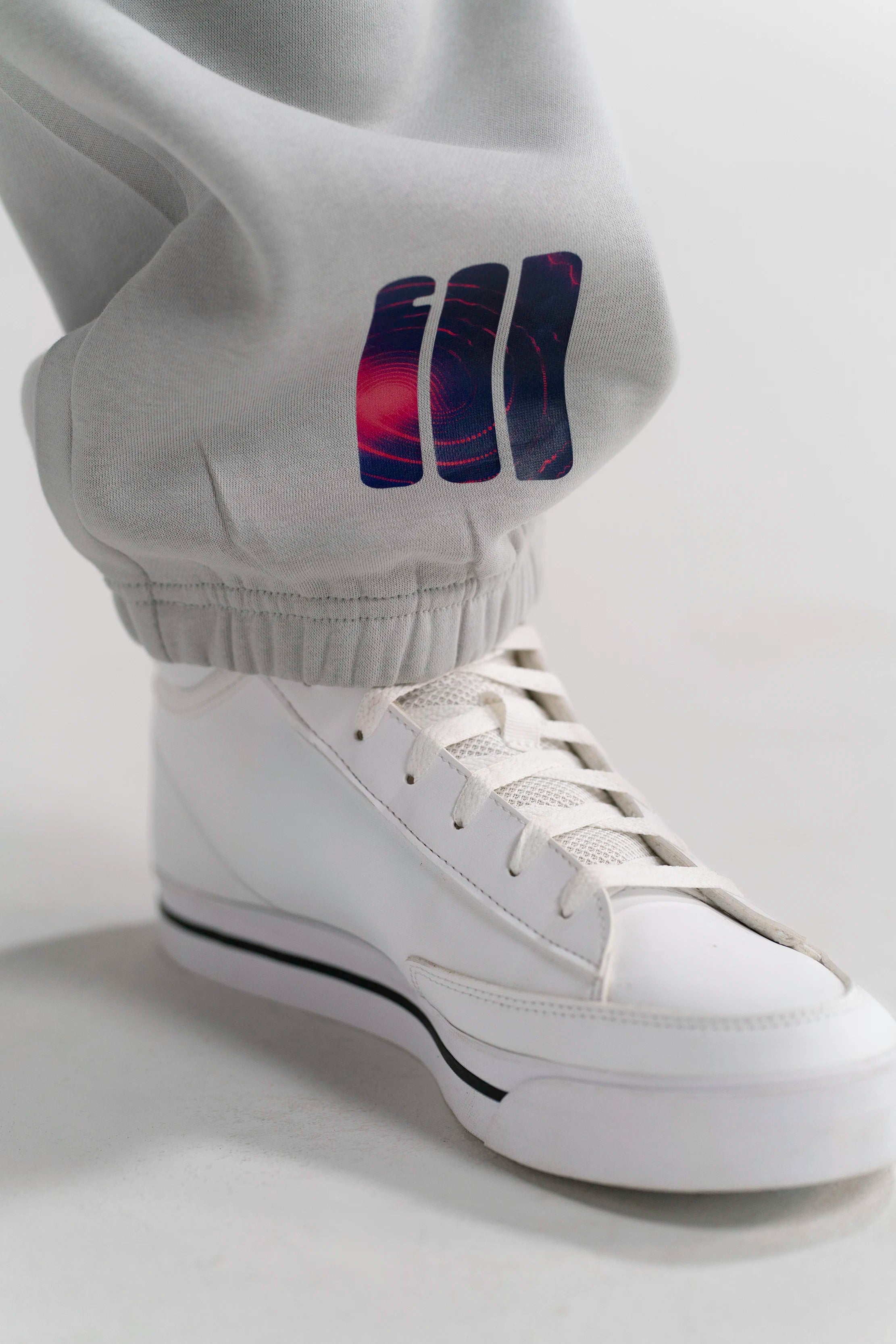 Detailaufnahme des GOD's Signal Prints auf der Open Source Signal Fluff Pants Gray von Source Mode. Relaxed Fit, hochwertiges Material und minimalistisches Design als Symbol für Verbindung, Präsenz und echtes Real Life.