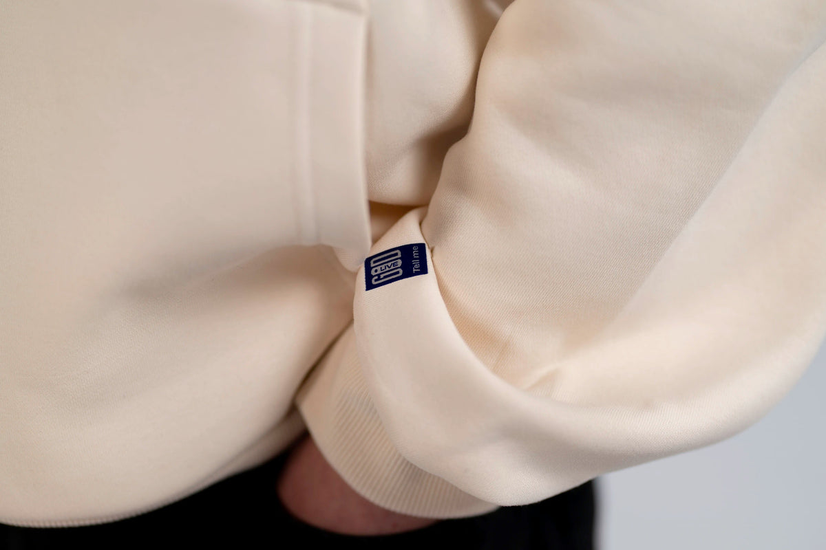 Detail: sleeve with Source Mode label on the Open Source Signal Hoodie in White Sand