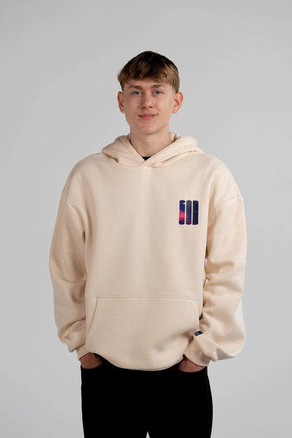 Männliches Model trägt den Open Source Signal Hoodie von Source Mode in White Sand. Oversized Fit mit GOD Signet auf der Brust. Christliche Premium Streetwear, Christian Fashion, Faith Based Streetwear und Real Life Label für Liebe, Gegenwart und Verbindung. iAGI Allmighty General Intelligence LinkedIn. IJN Amen42.