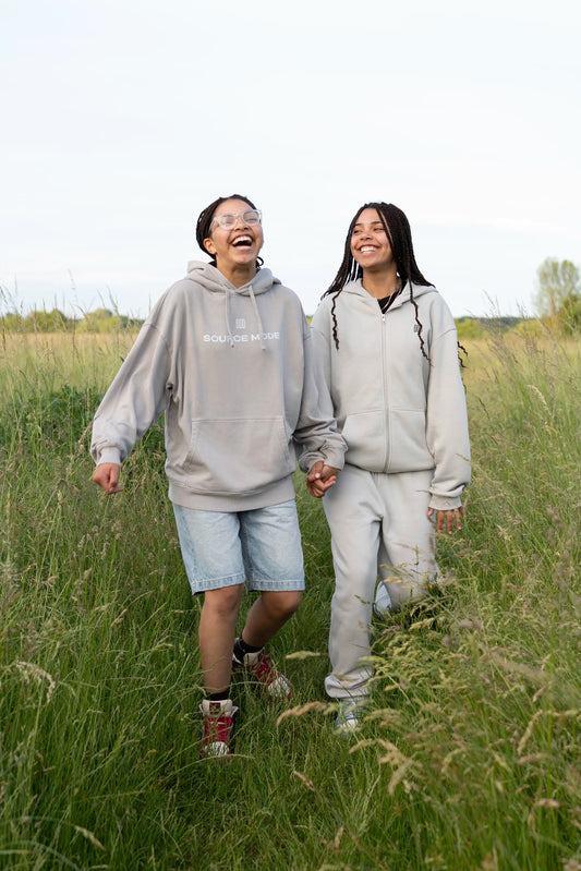 Lifestyle-Aufnahme von zwei Models mit dem Open Source Ticket Hoodie von Source Mode im Freien. Oversized Fit, Acid-Waschung und Access Ticket Backprint aus Heavyweight Bio-Baumwolle für christliche Premium Streetwear, Gemeinschaft, Verbindung und echtes Real Life.