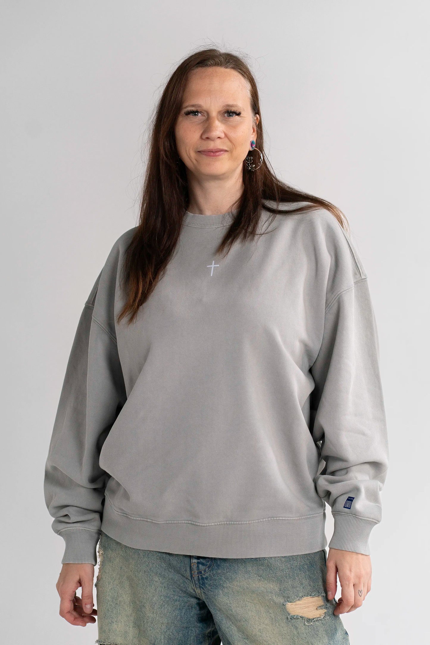 Model trägt den Open Source Ticket Sweater von Source Mode in Frontansicht. Oversized Fit, Heavyweight Bio-Baumwolle, Garment-Dyed Finish und Kreuz Front Print für christliche Premium Streetwear.