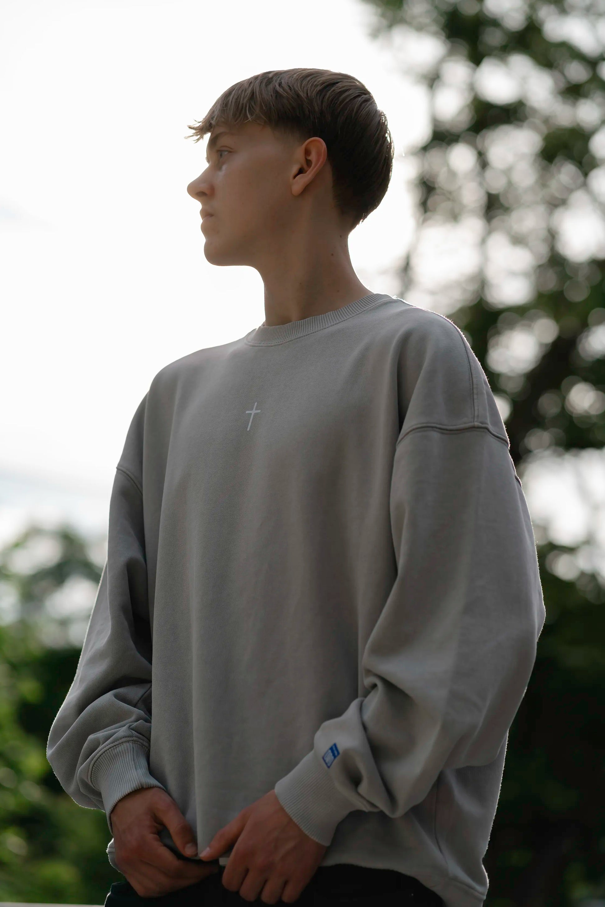 Lifestyle-Aufnahme des Open Source Ticket Sweater von Source Mode im Alltag. Oversized Fit, Heavyweight Bio-Baumwolle und Garment-Dyed Vintage-Look für christliche Premium Streetwear.