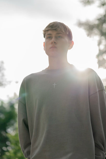 Portraitaufnahme des Open Source Ticket Sweater von Source Mode im natürlichen Licht. Oversized Fit, Garment-Dyed Vintage-Look und Heavyweight Bio-Baumwolle.