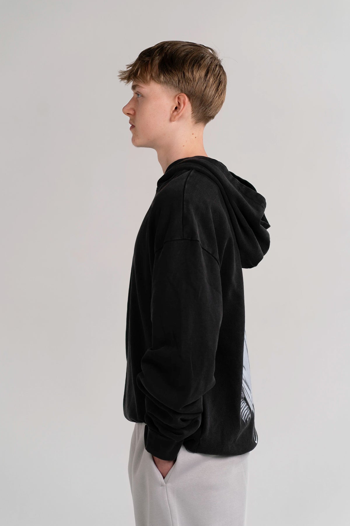Side view of the Open Source Jesus Presence Hoodie in Washed Black on a model