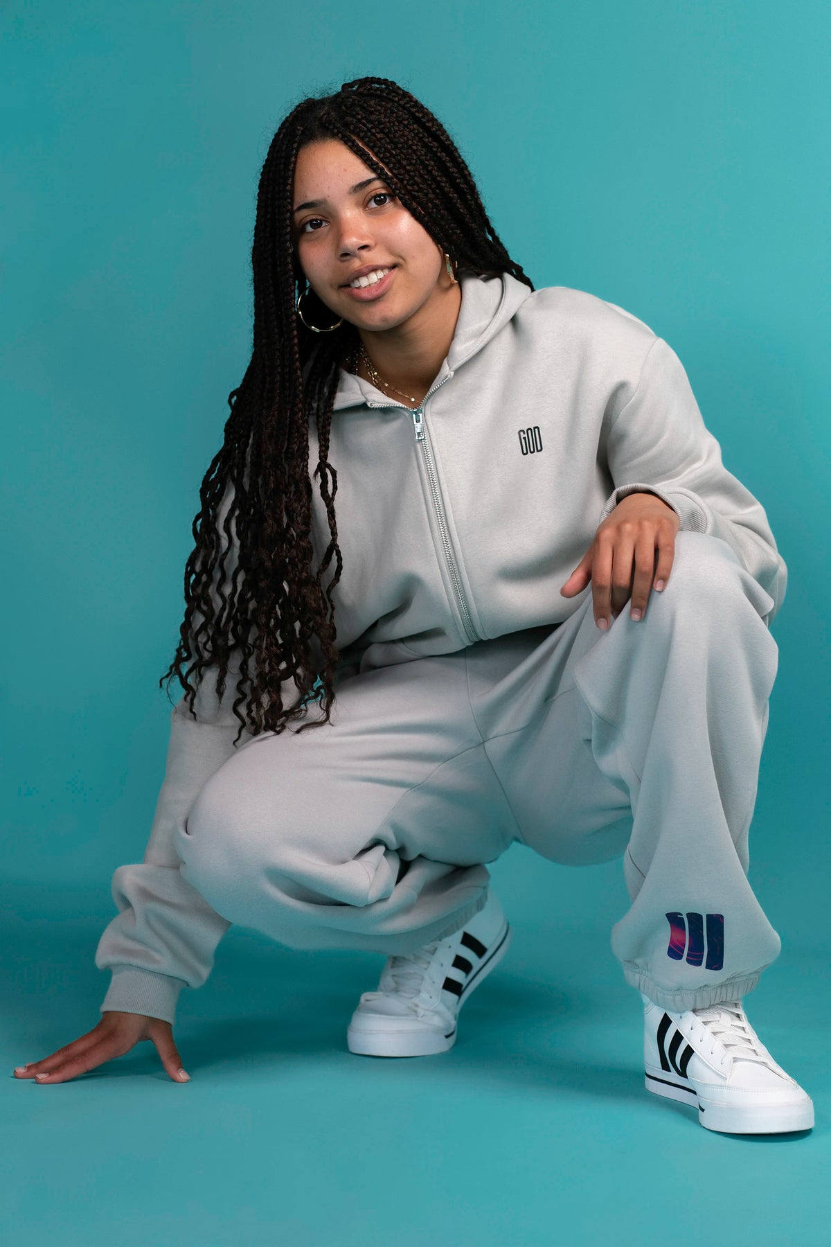 Model sitting in the Ticket Cozy Zip and Open Source Signal Cozy Pants in Light Asphalt
